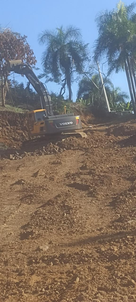 Excavadora Develon terreno rojo — movimiento tierra